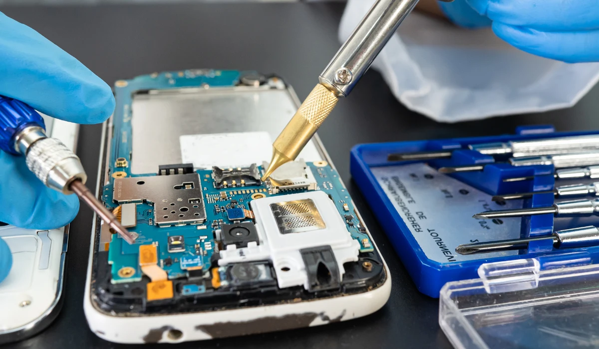 Un tecnico ispeziona un computer portatile in un'officina, illustrando il processo di ricondizionamento